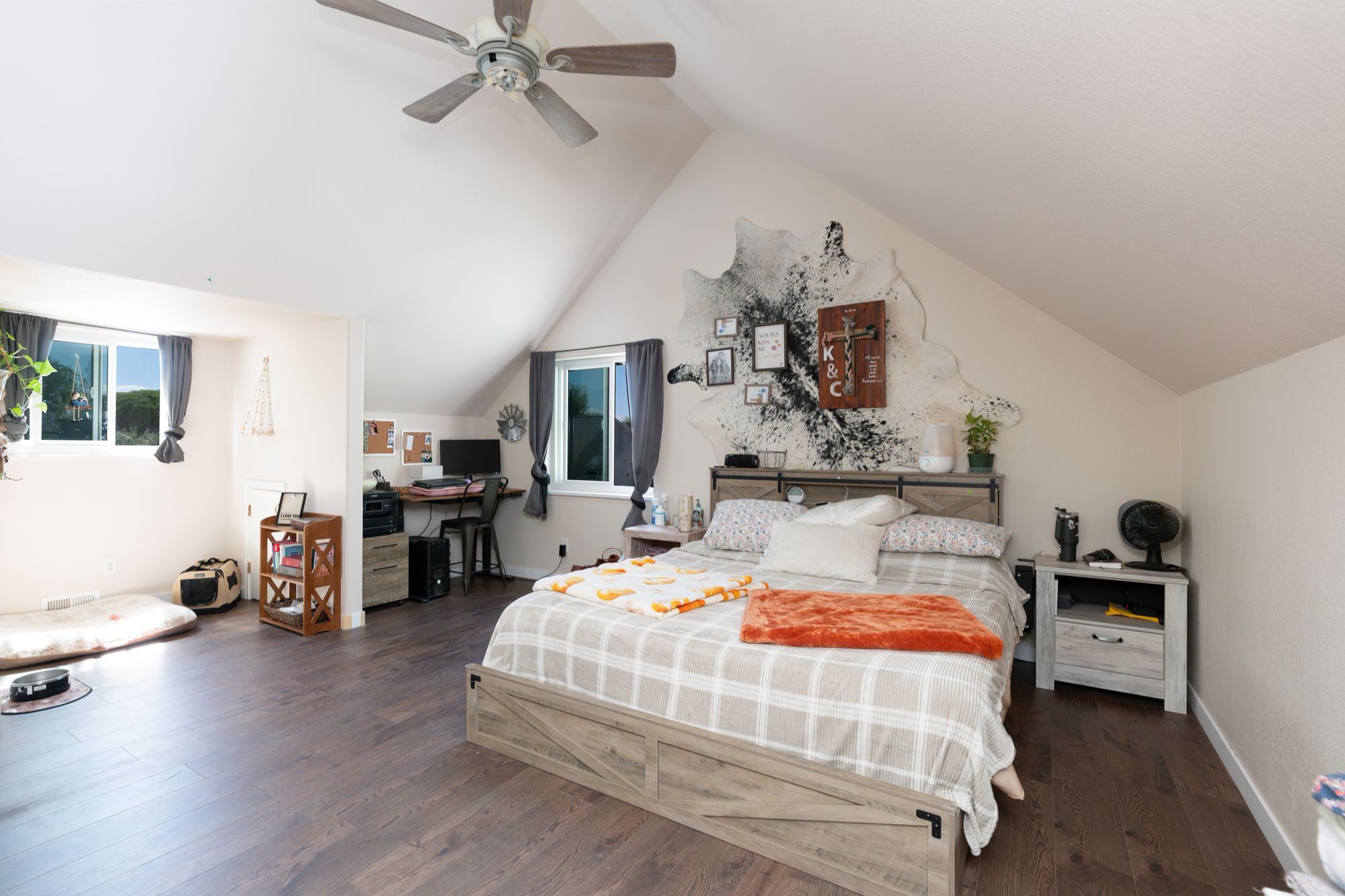 Upstairs bedroom with vaulted ceiling and ceiling fan