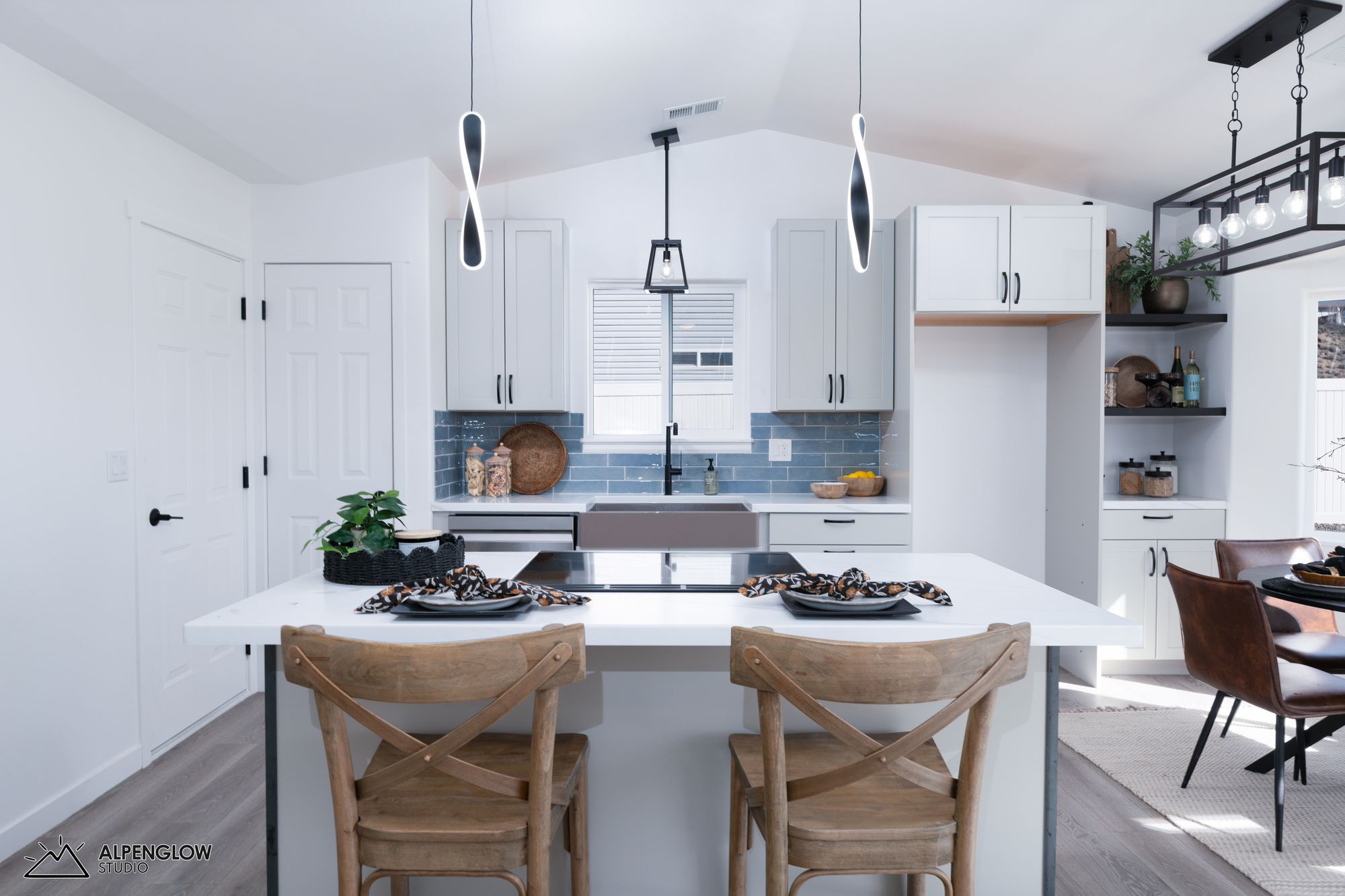 Modern kitchen with blue tile backsplash, pendant lights, and island seating