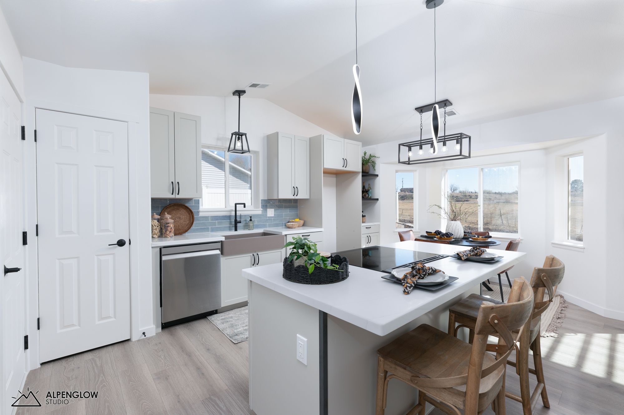 Open kitchen with blue tile backsplash, farmhouse sink, and pendant lighting